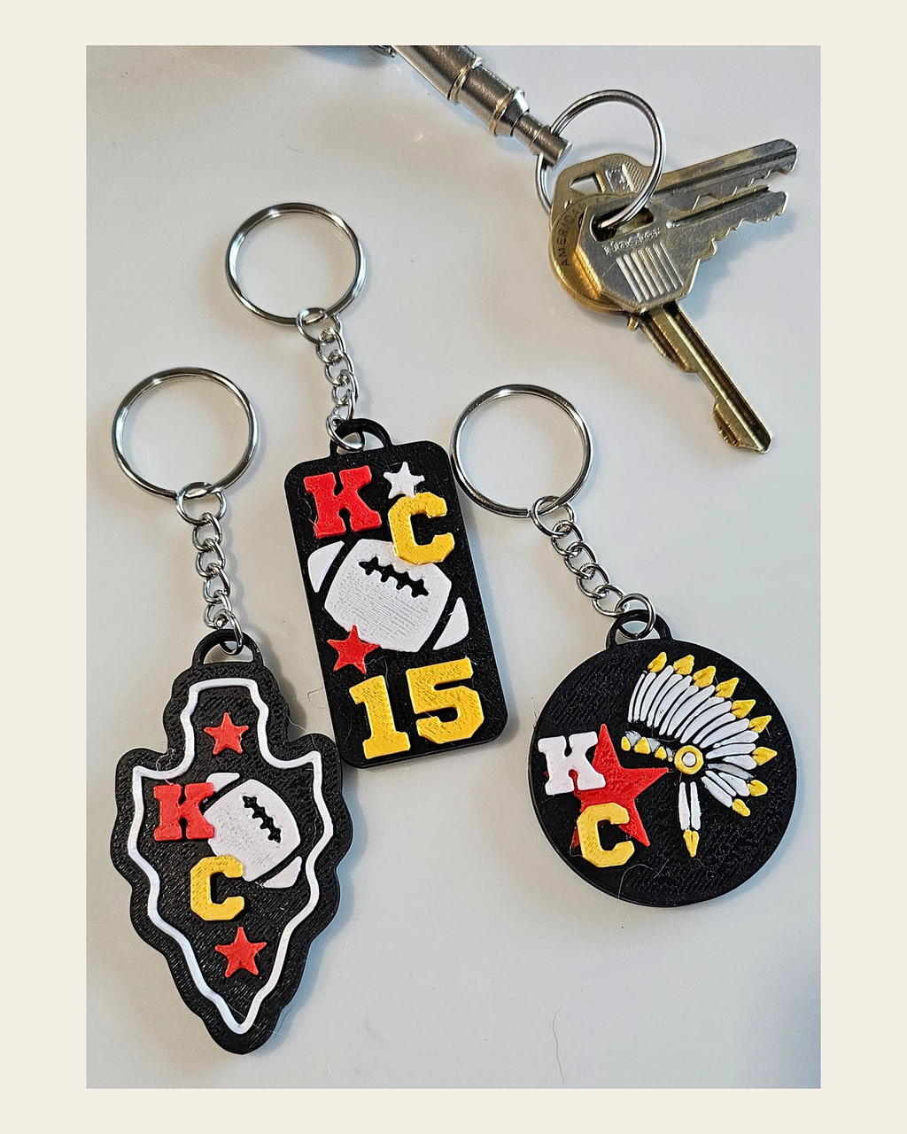 Set of 3 3D Print Chiefs Arrowhead Kc Kansas City 15 Football Keychains Made in America on a warm cream background