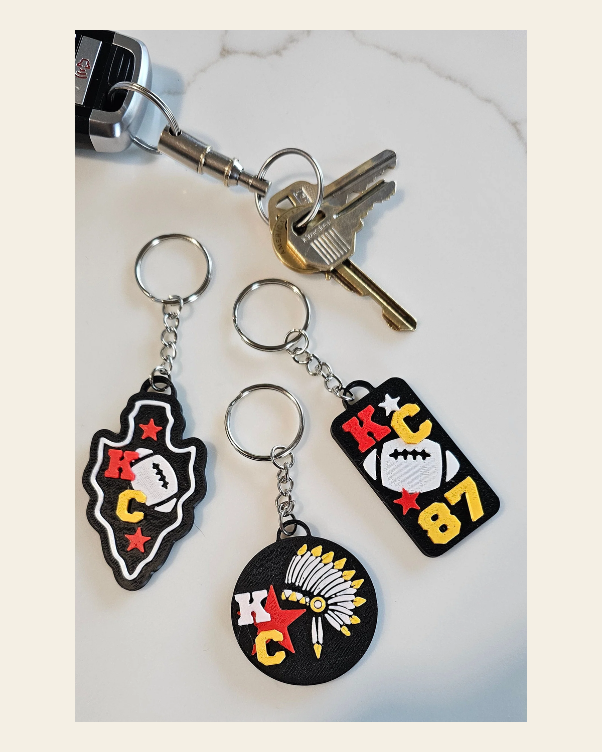 Set of 3 3D Print Chiefs Arrowhead Kc Kansas City 87 Football Keychains Made in America on a warm cream background