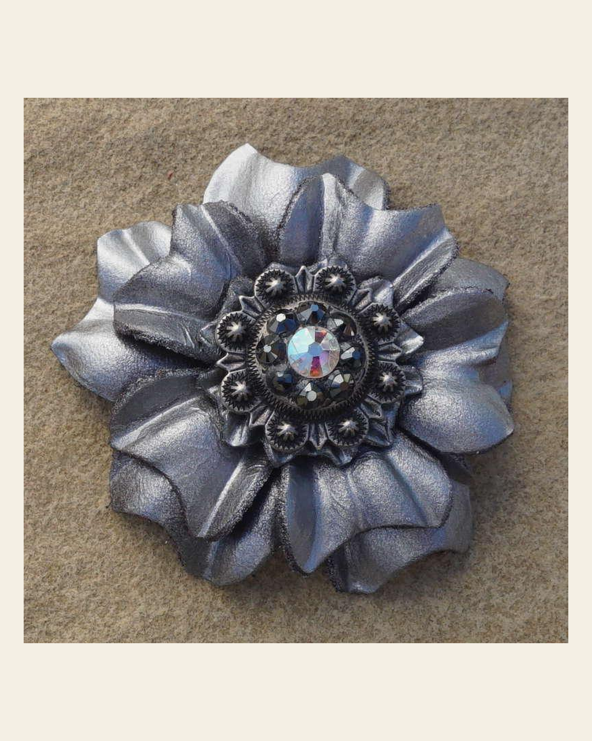 Silver Carnation Flower With Antique Silver Jet and AB 1" Concho on a warm cream background