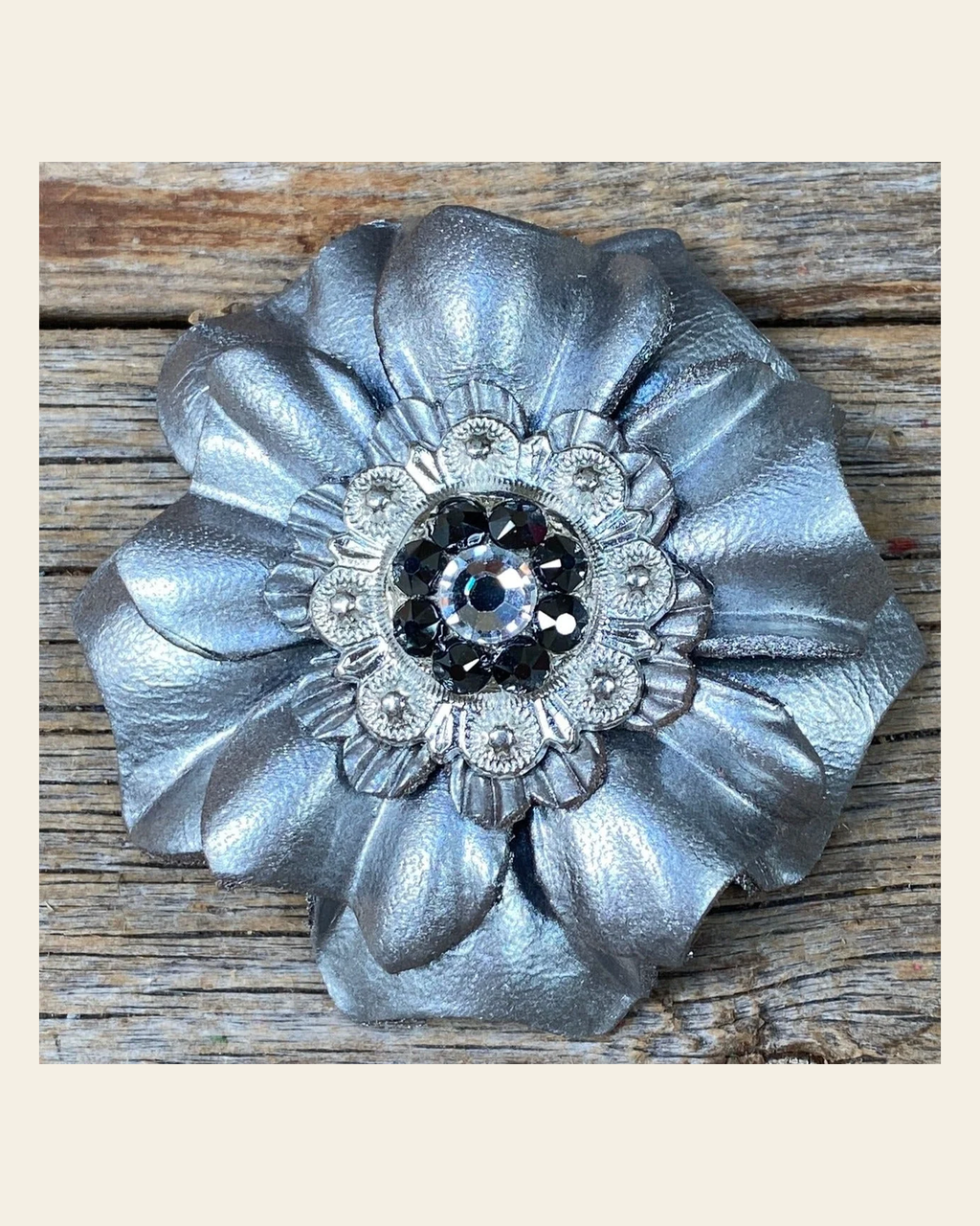 Silver Carnation Flower With Bright Silver Jet, Clear 1" Concho on a warm cream background