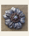 Silver Carnation Flower With Copper Jet & AB 1" Concho on a warm cream background