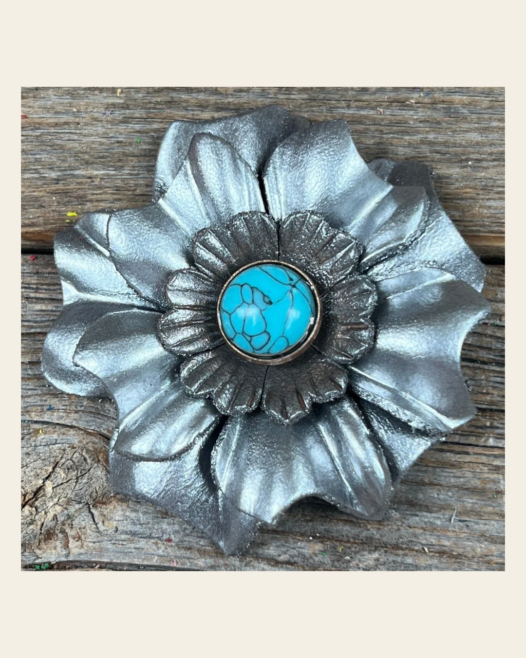 Silver Carnation Flower With Round Turquoise Cabochon on a warm cream background