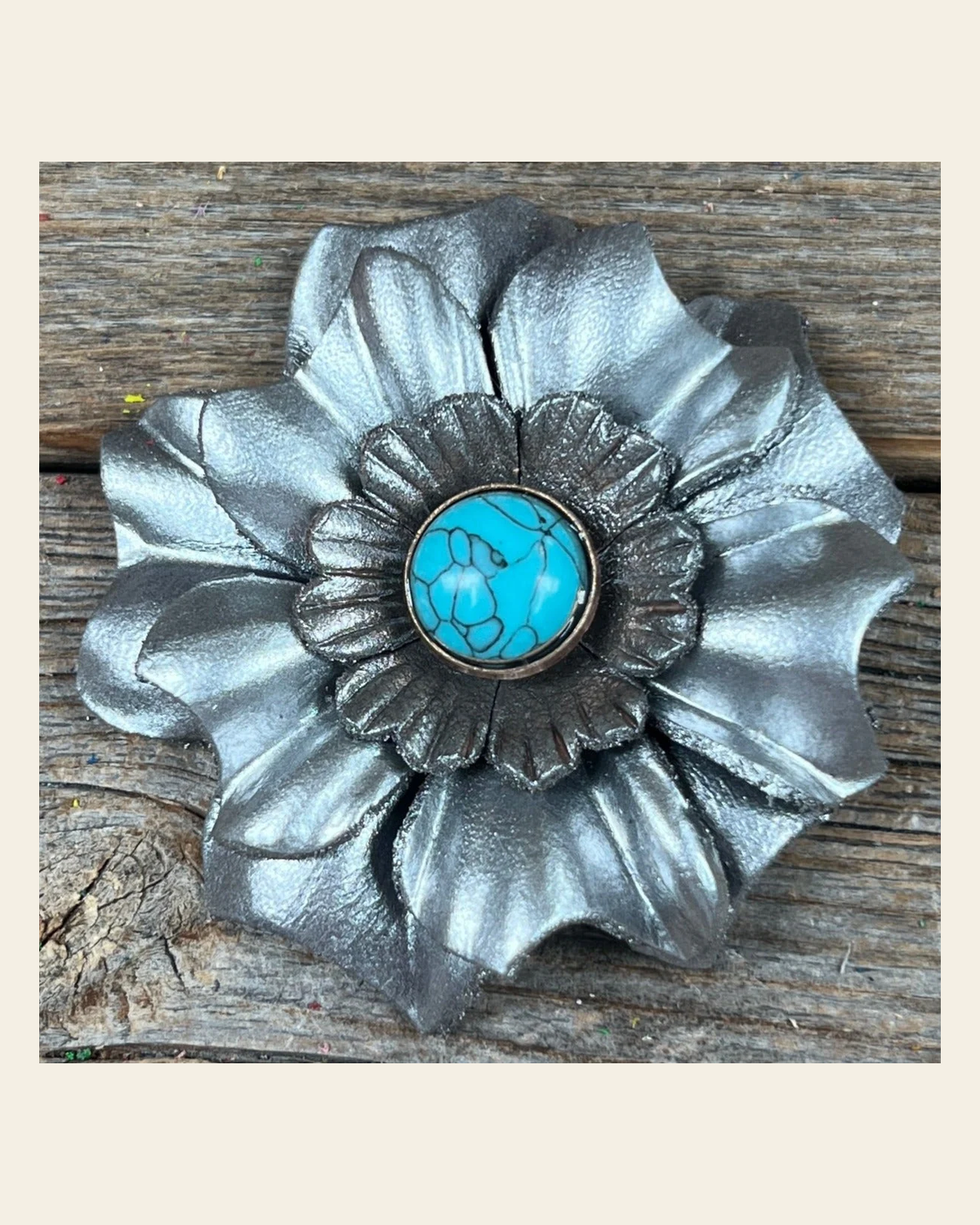 Silver Carnation Flower With Round Turquoise Cabochon on a warm cream background