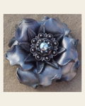 Silver Gardenia Flower With Antique Silver Jet & AB 1" Concho on a warm cream background