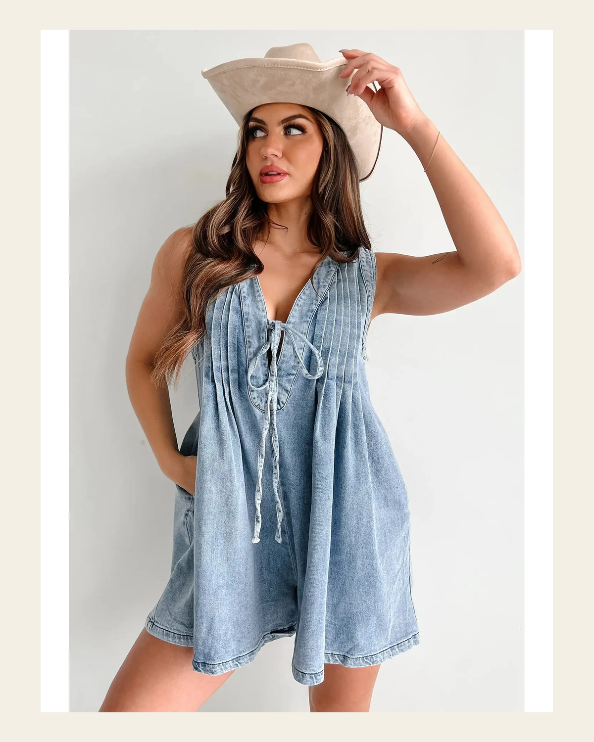 Skye Denim Pleated | Romper on a warm cream background