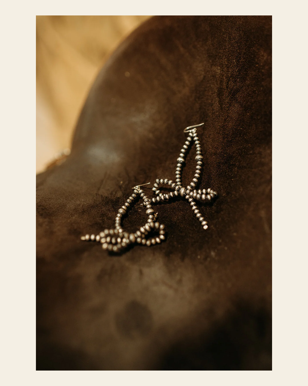 Sterling Silver Navajo Inspired Bow Tie Pearl Dangle Earring on a warm cream background
