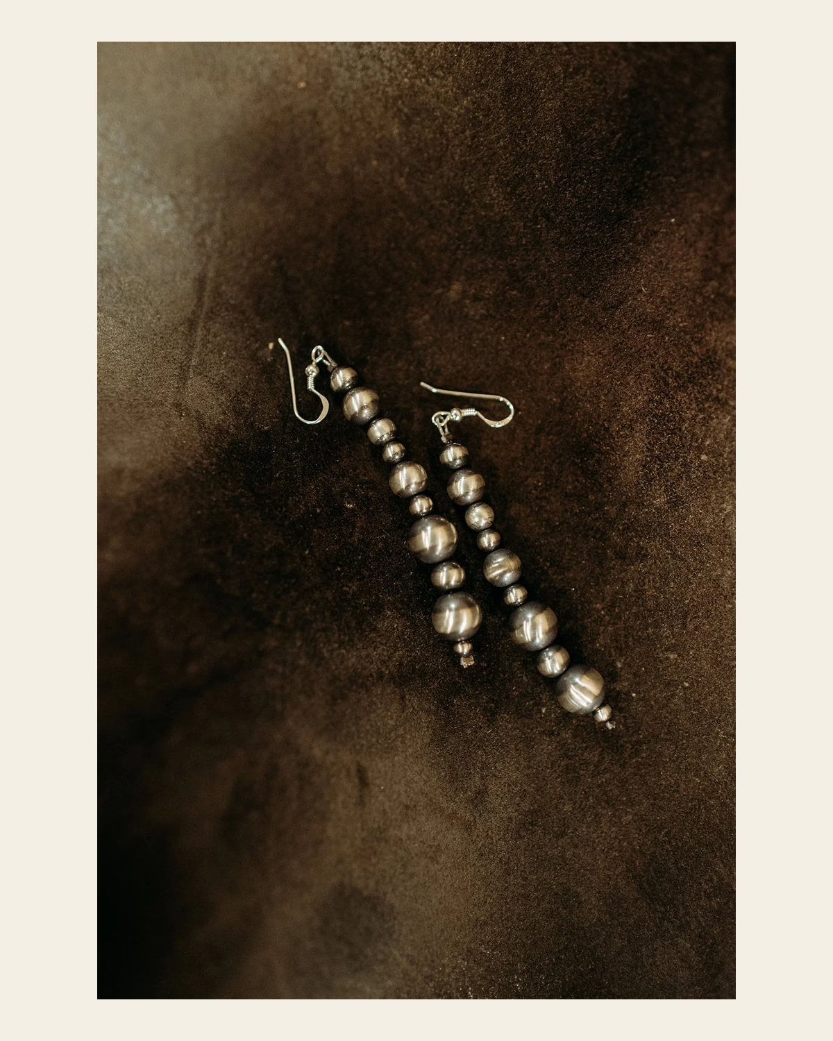 Sterling Silver Hand-strung Long Pearl Dangle Earring on a warm cream background