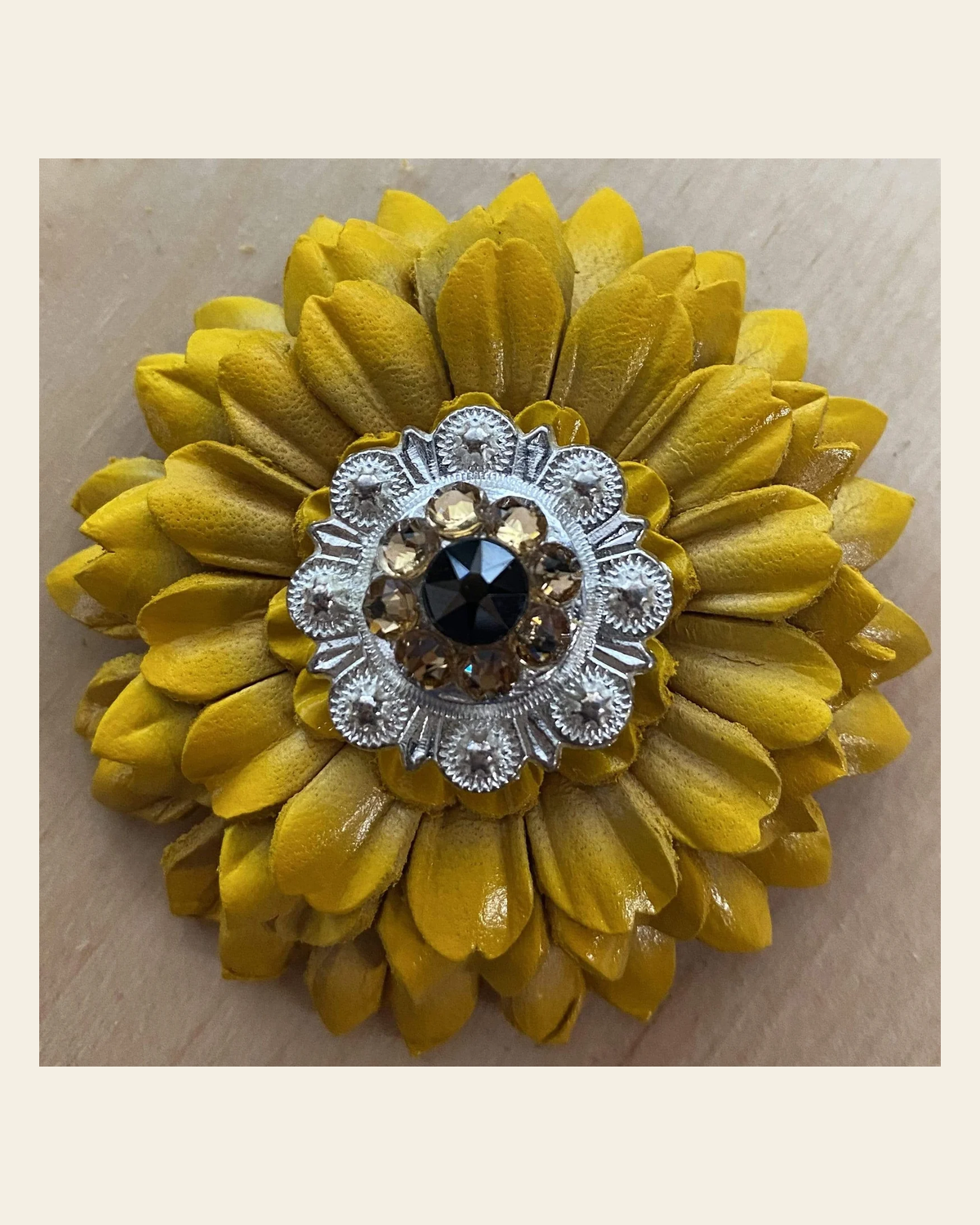 Sunflower with Bright Silver Jet & Champagne 1" Concho on a warm cream background