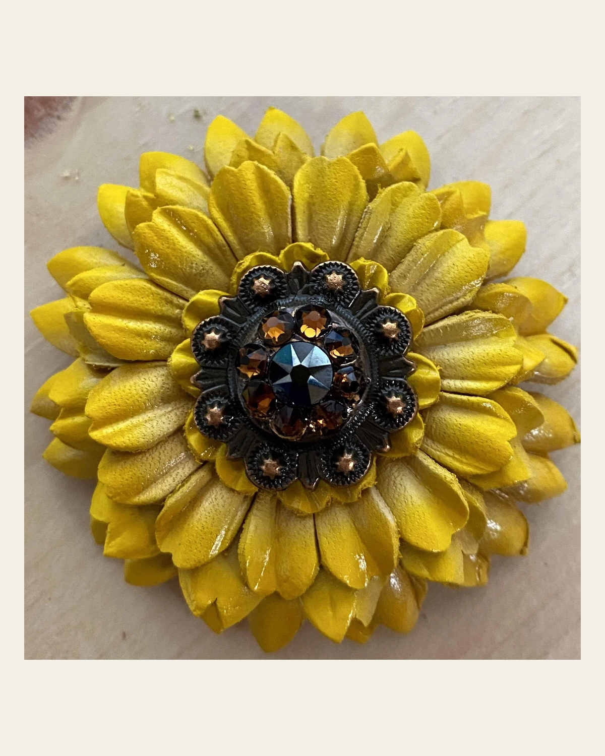 Sunflower With Copper Jet & Topaz 1" Concho on a warm cream background