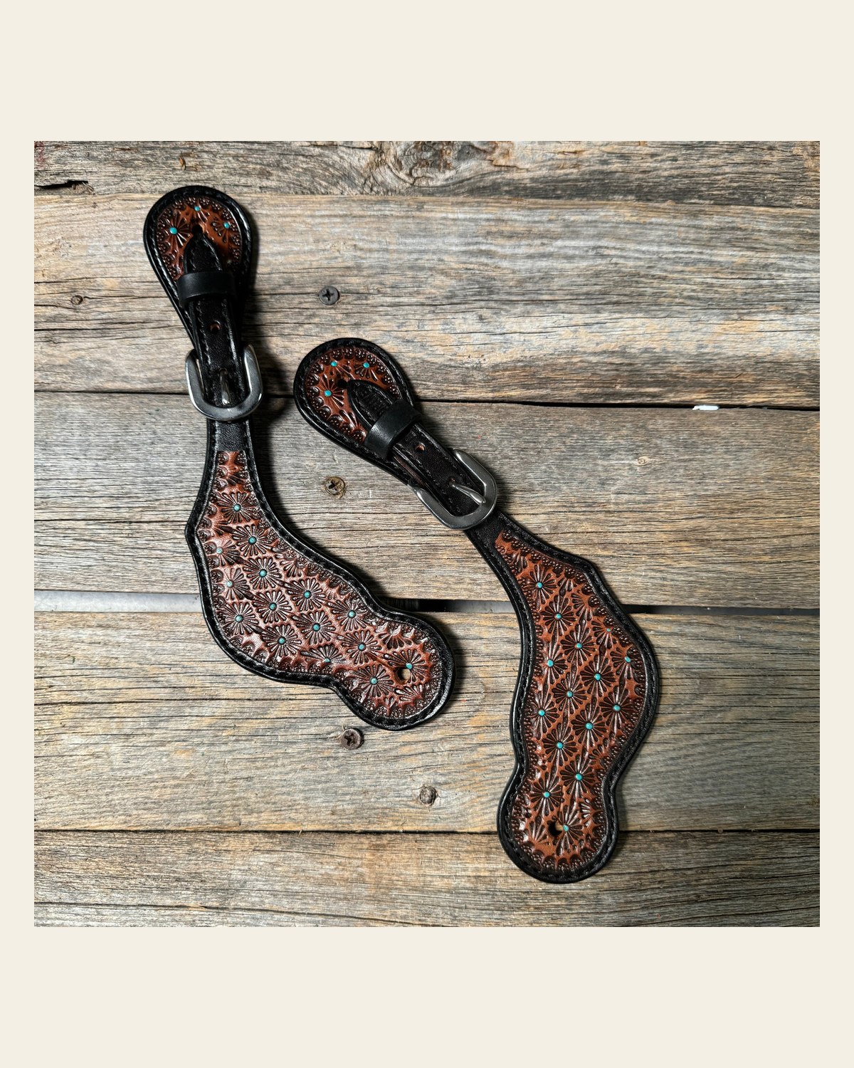 Teal Dot Diamond Tooled Spur Straps on a warm cream background