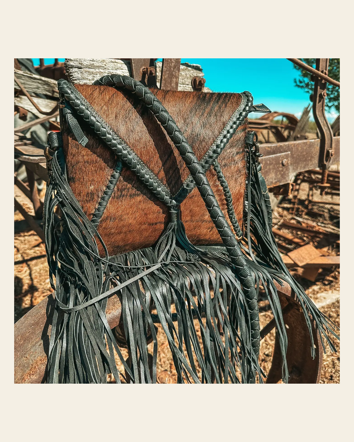 The Xia - Brindle Cowhide Fringe | Purse on a warm cream background