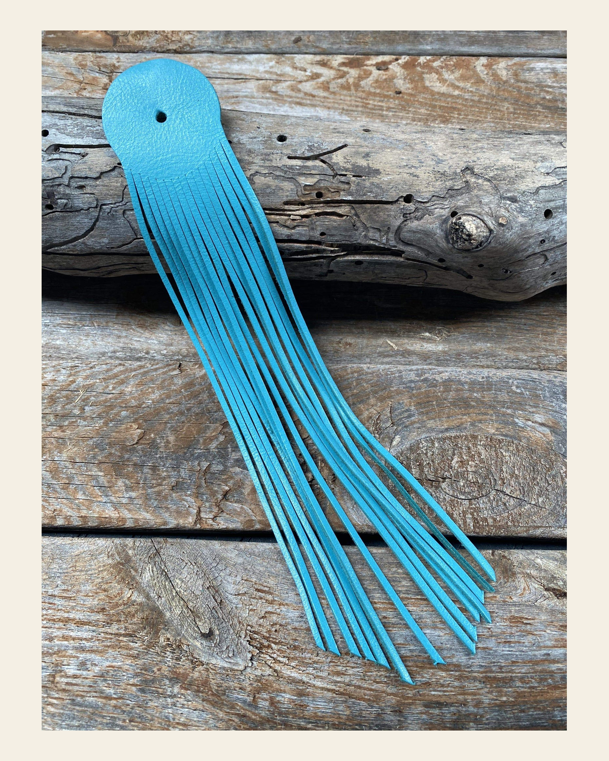 Turquoise Leather Fringe on a warm cream background