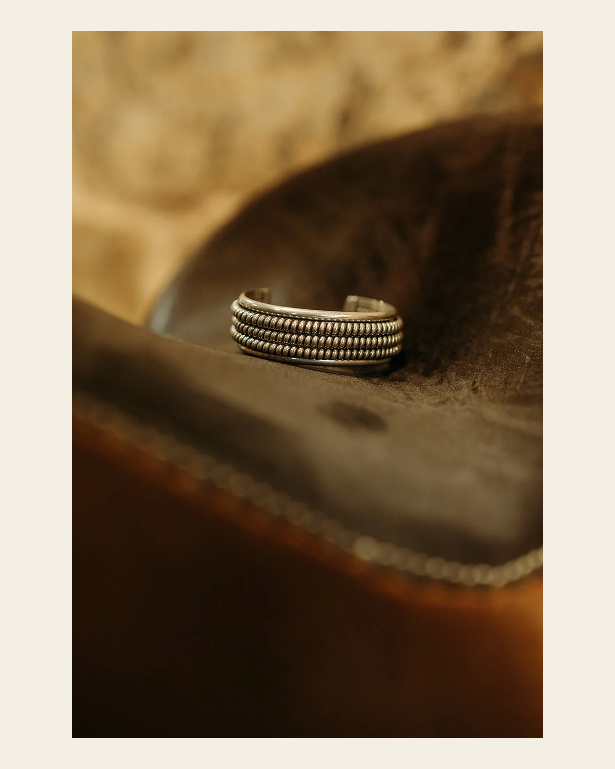 Twisted Sterling Silver Cuff By Caroline Tsosie on a warm cream background