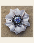 White Carnation Flower With Antique Silver Lilac and Light Sapphire 1" Concho on a warm cream background
