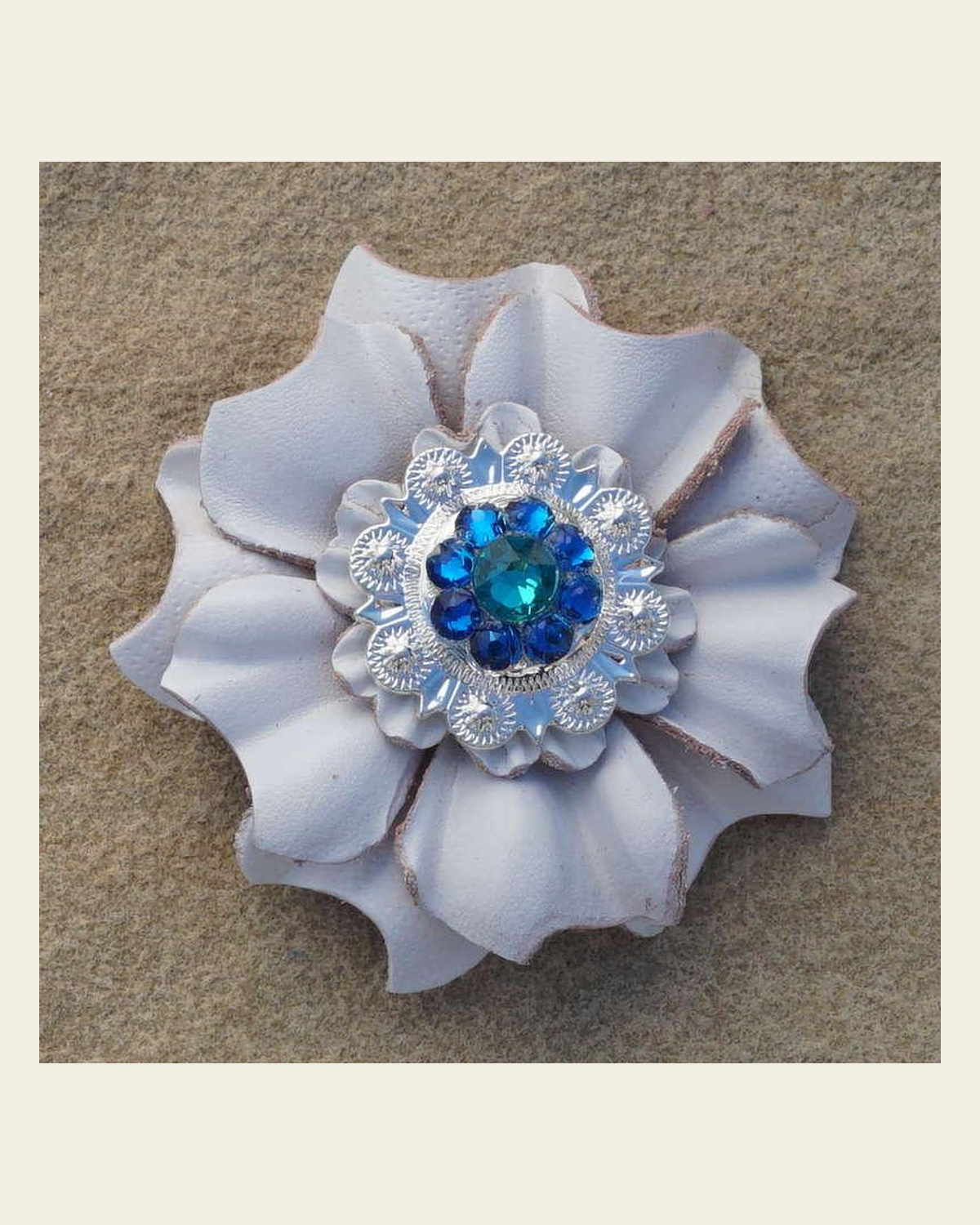 White Carnation Flower With Bright Silver Teal and Capri 1" Concho on a warm cream background
