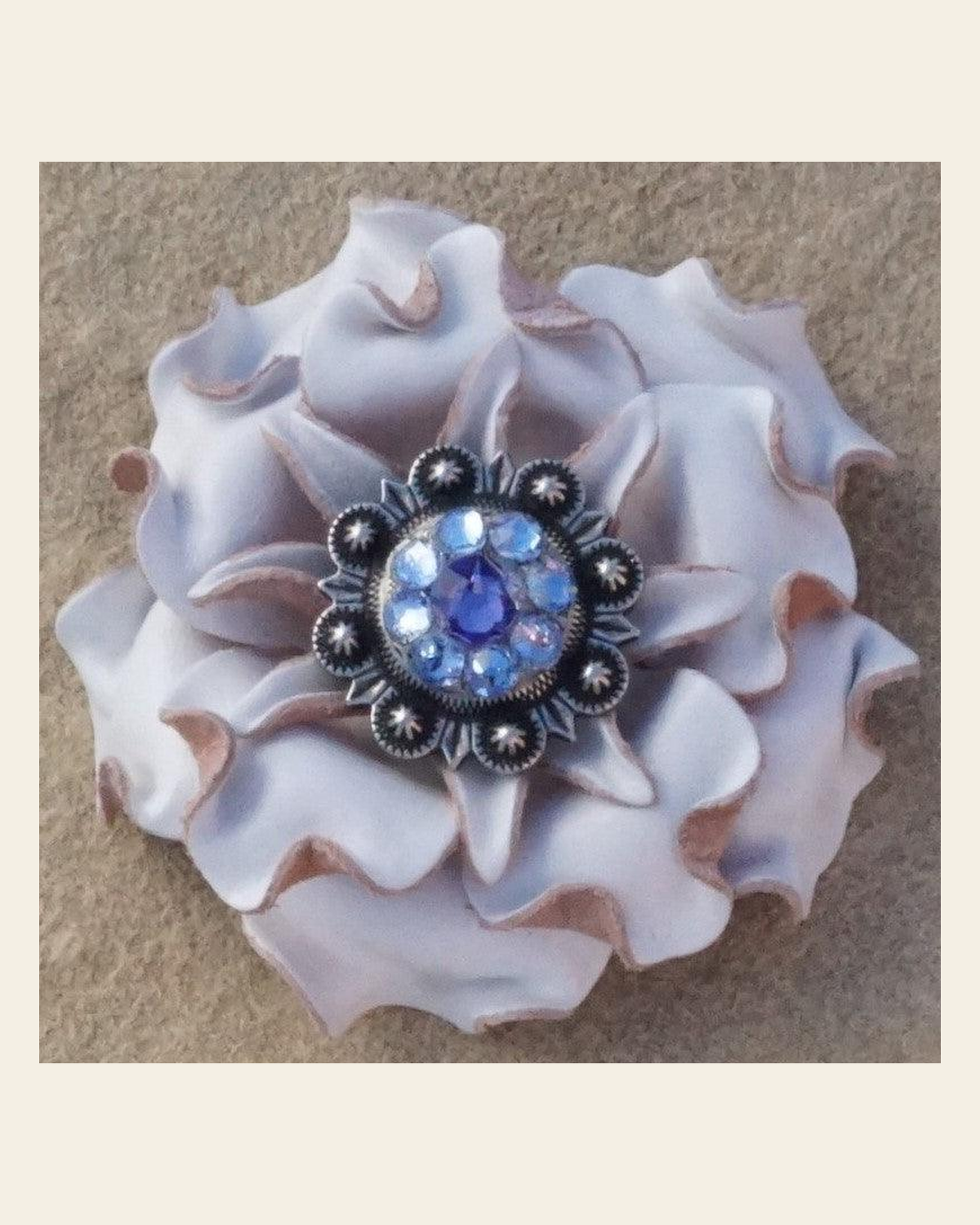 White Gardenia Flower With Antique Silver Lilac and Light Sapphire 1" Concho on a warm cream background