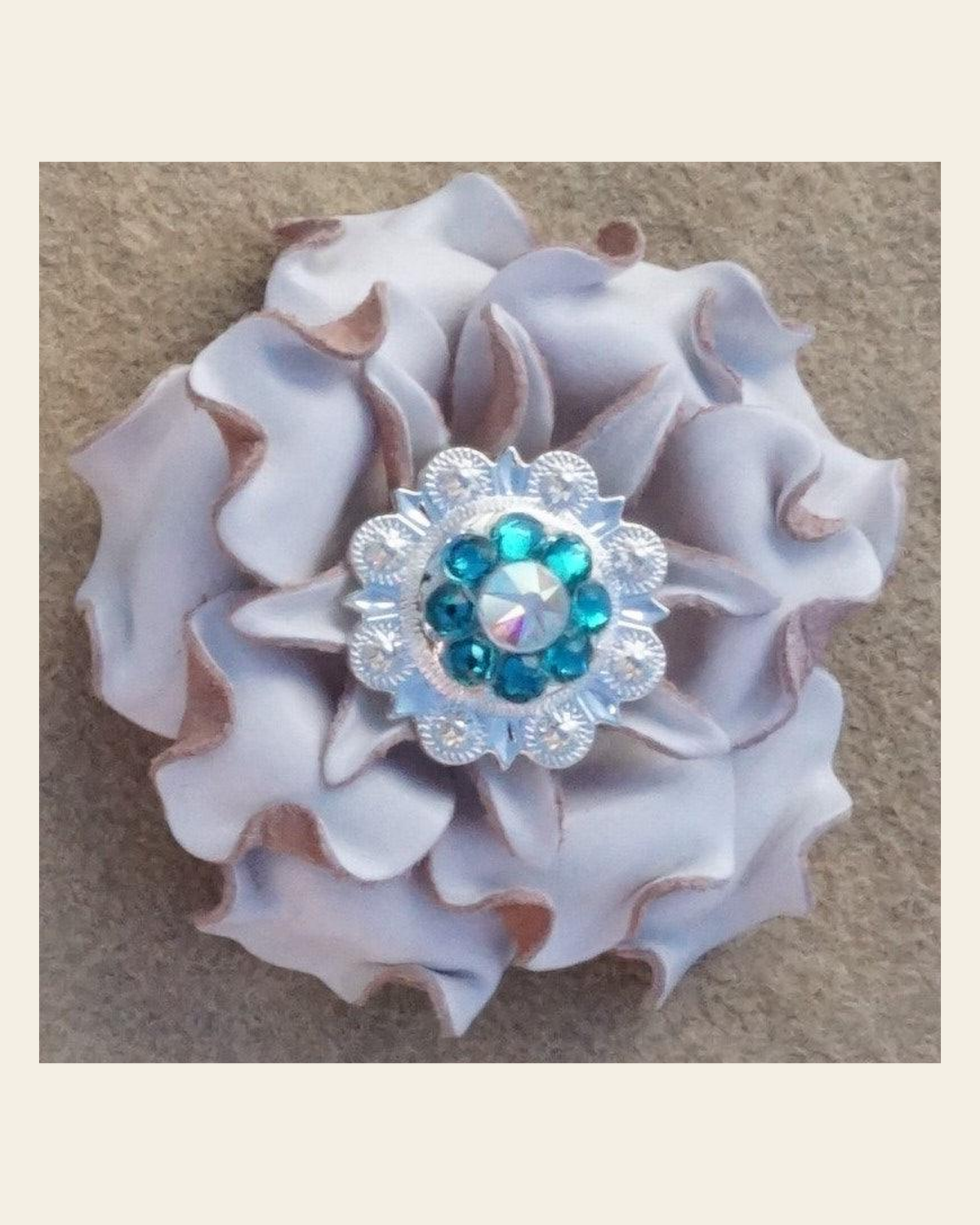 White Gardenia Flower With Bright Silver Teal and AB 1" Concho on a warm cream background