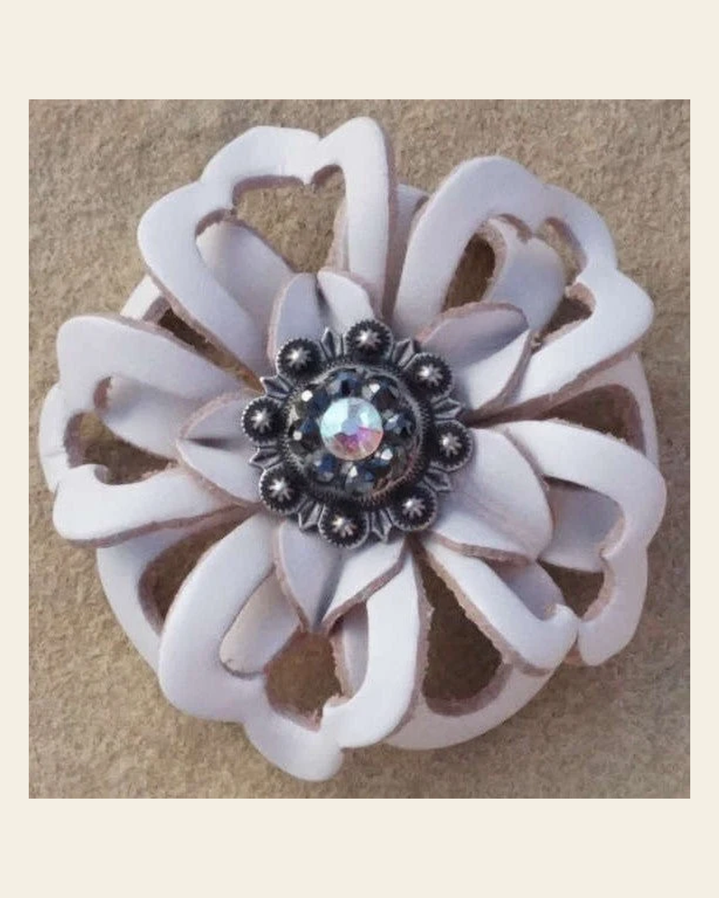 White Lotus Flower With Antique Silver Jet and AB 1" Concho on a warm cream background