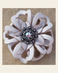 White Lotus Flower With Antique Silver Jet and AB 1" Concho on a warm cream background