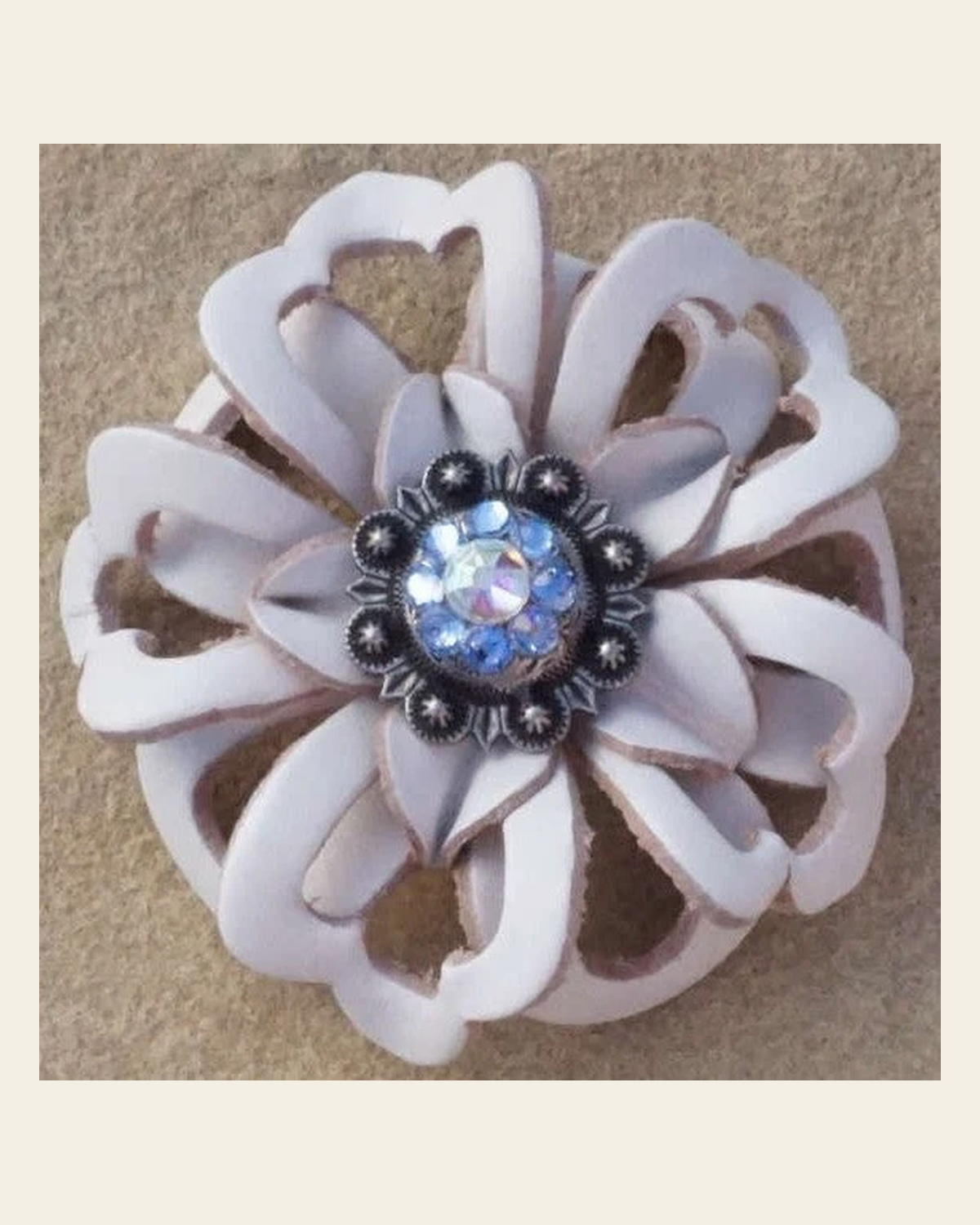White Lotus Flower With Antique Silver Light Sapphire and AB 1" Concho on a warm cream background