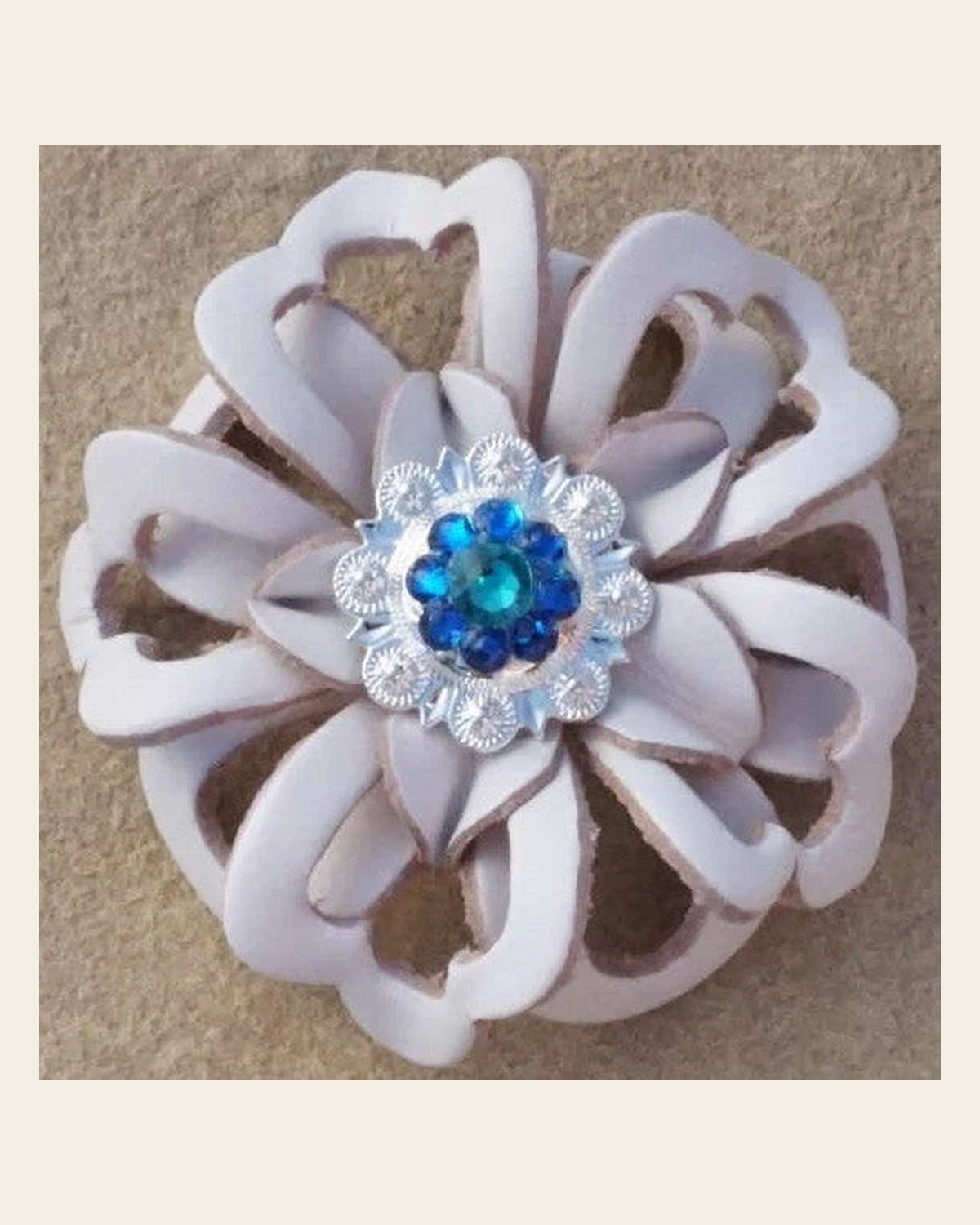 White Lotus Flower With Bright Silver Teal and Capri 1" Concho on a warm cream background