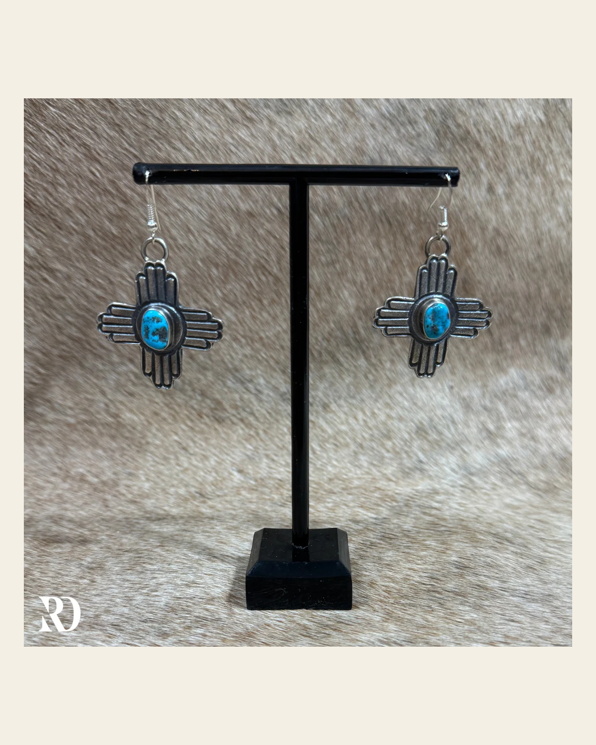 Zia Kingman Turquoise Earrings By Kevin Billah on a warm cream background